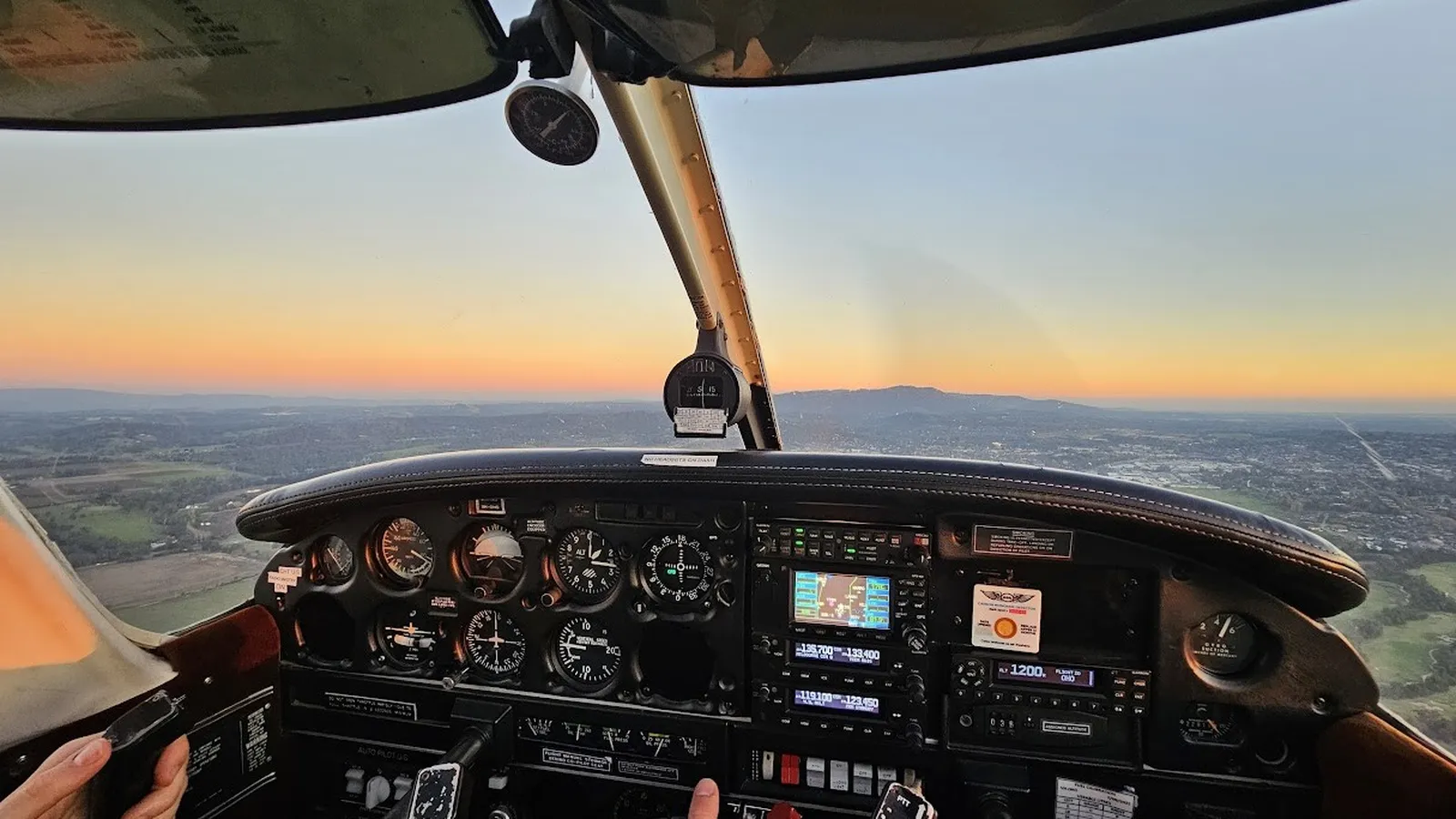 A piper warrior flying during sunset